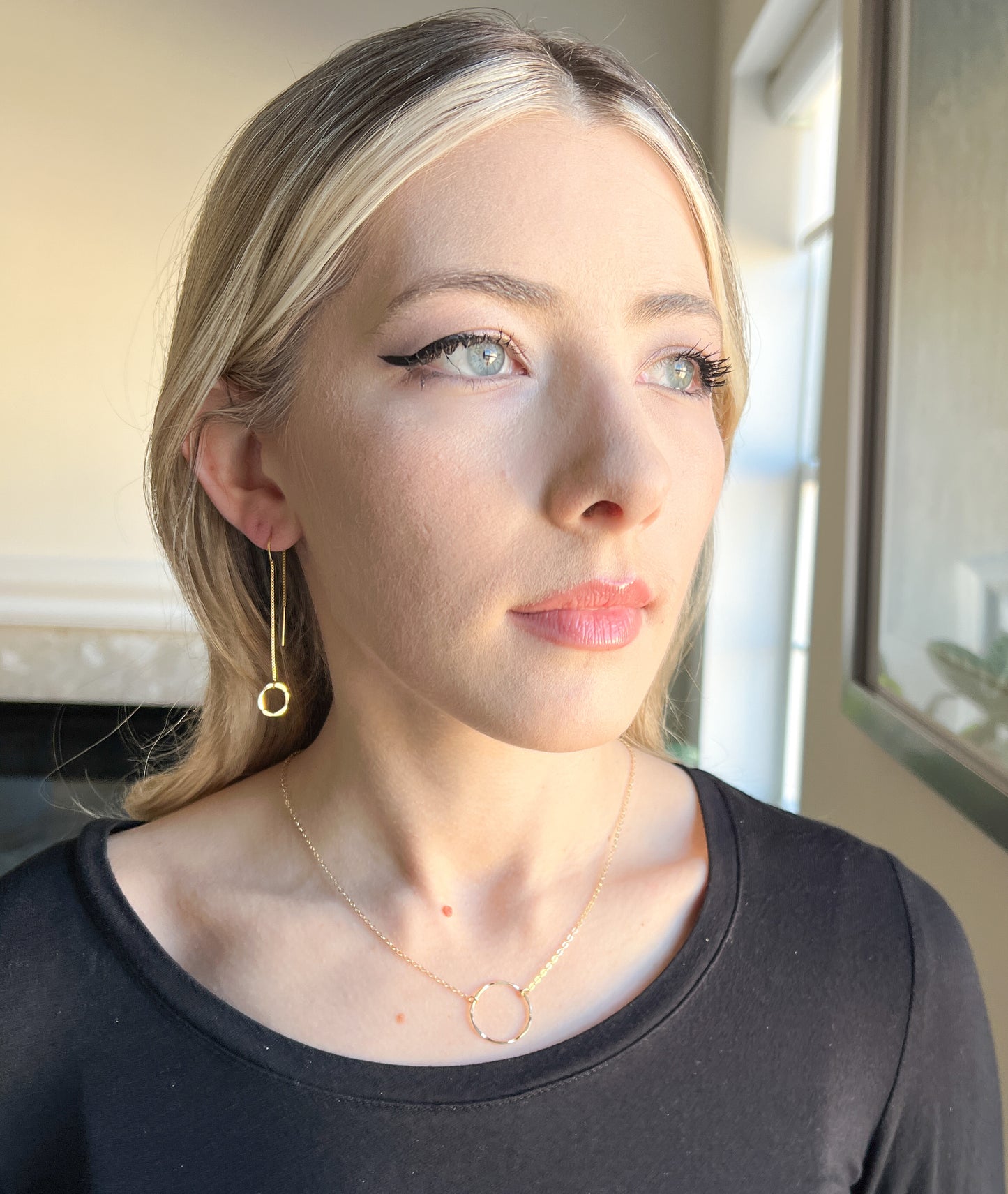 Lightweight threader earrings. Model is wearing long dangle gold threader earrings with small gold hammered circle in front.