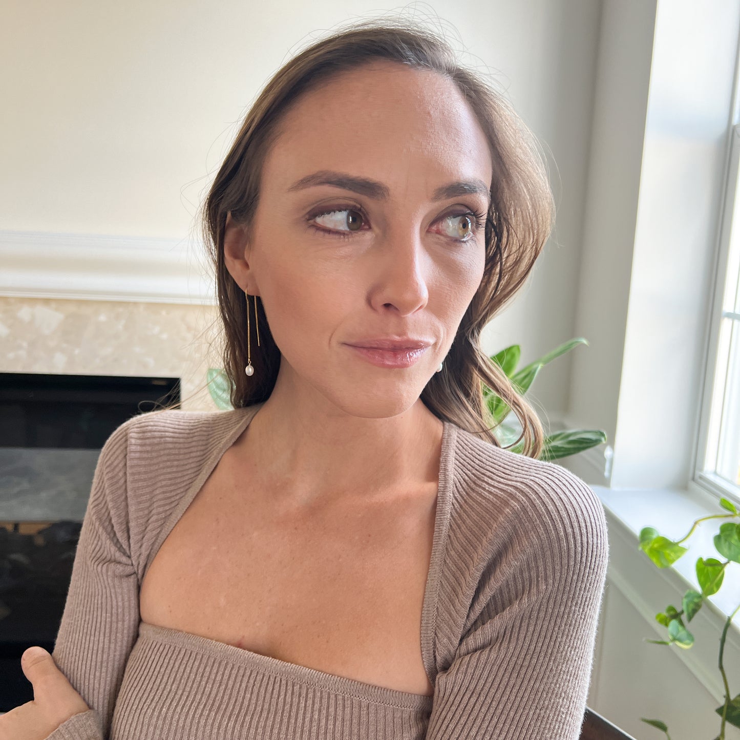 model wearing pearl threader earrings