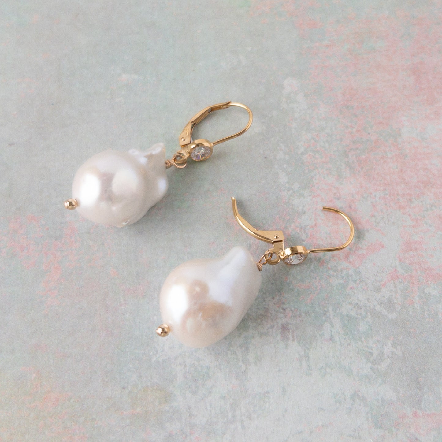 close up of large pearl earrings on leverback ear wires