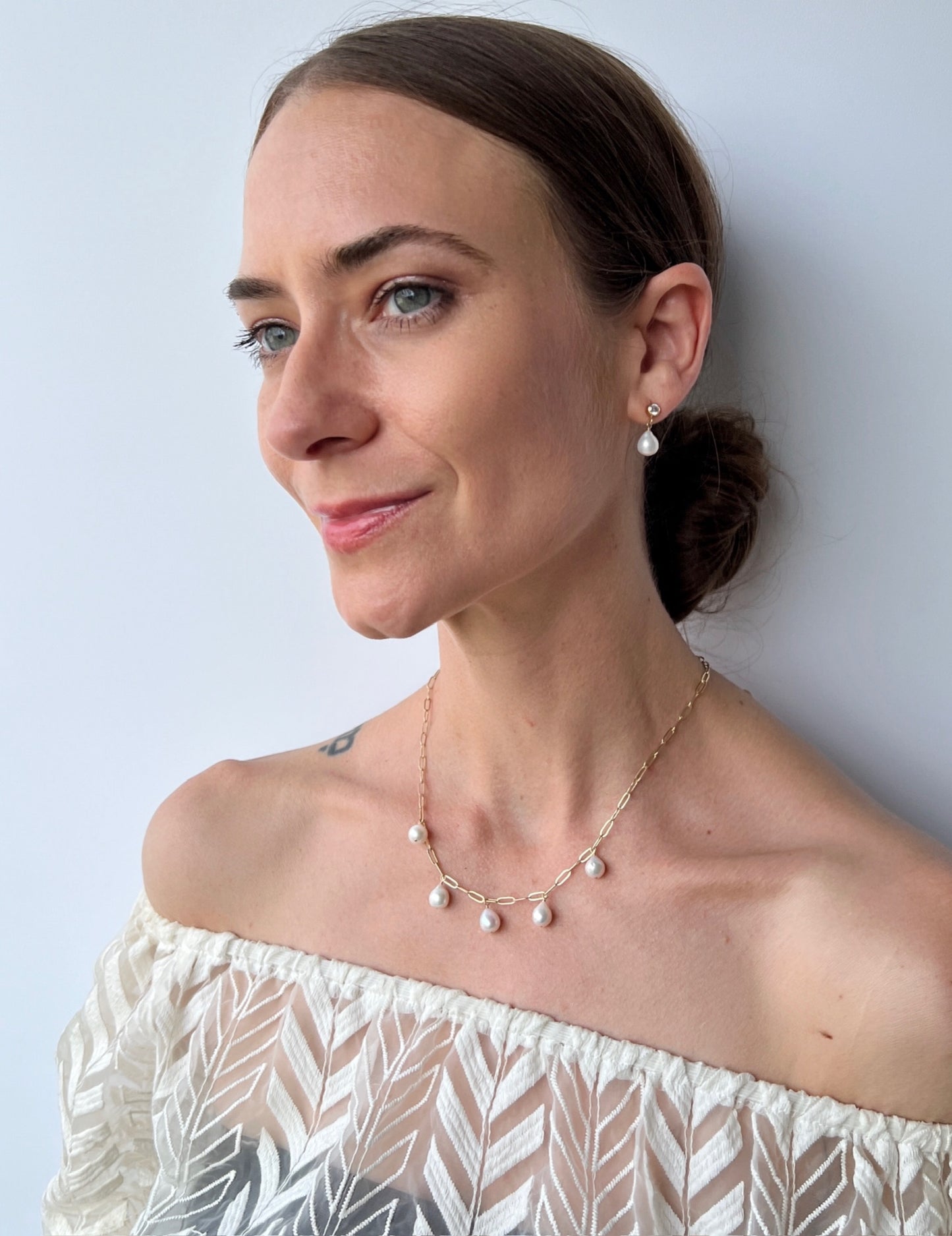 model wearing pearl charm necklace with matching stud earrings from the Vivara Collection