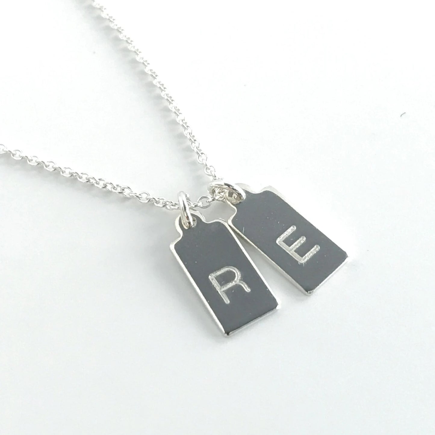 close up of single letter engraved mini dog tags