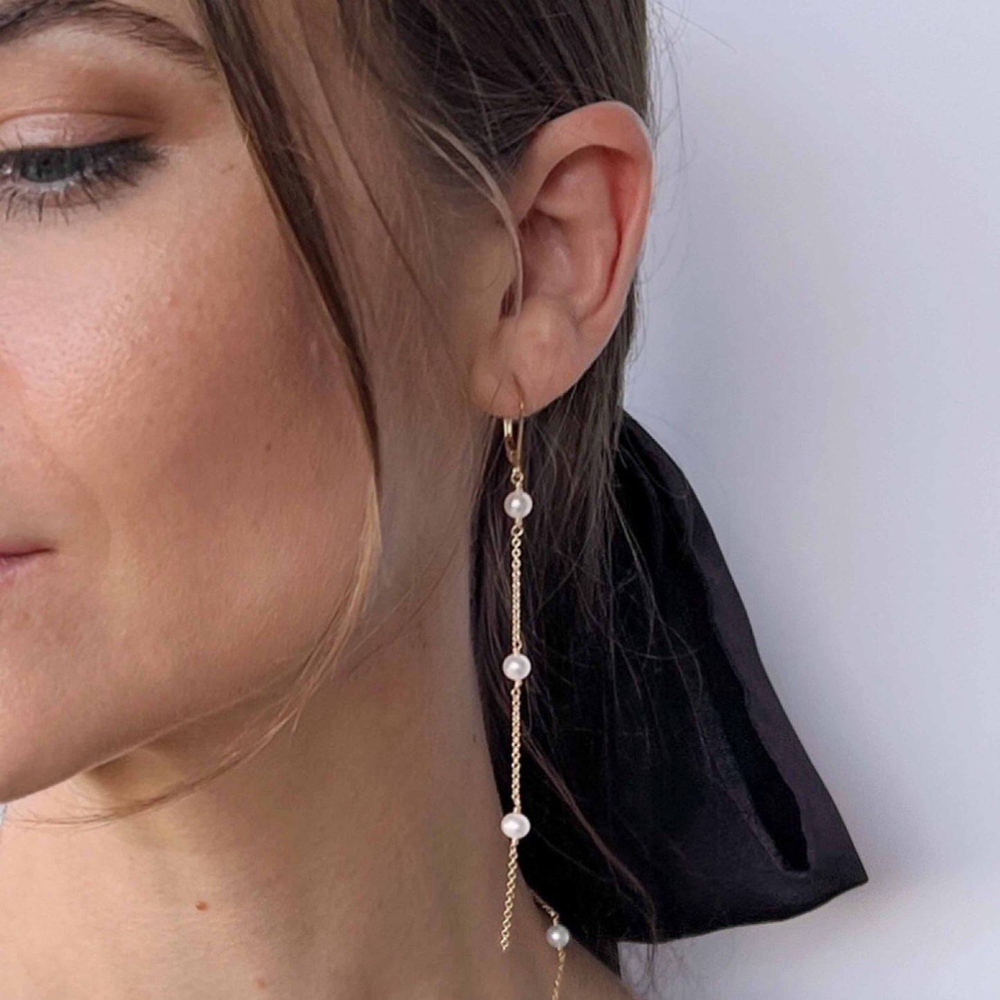 model wearing long pearl dangle earrings from Lucia collection