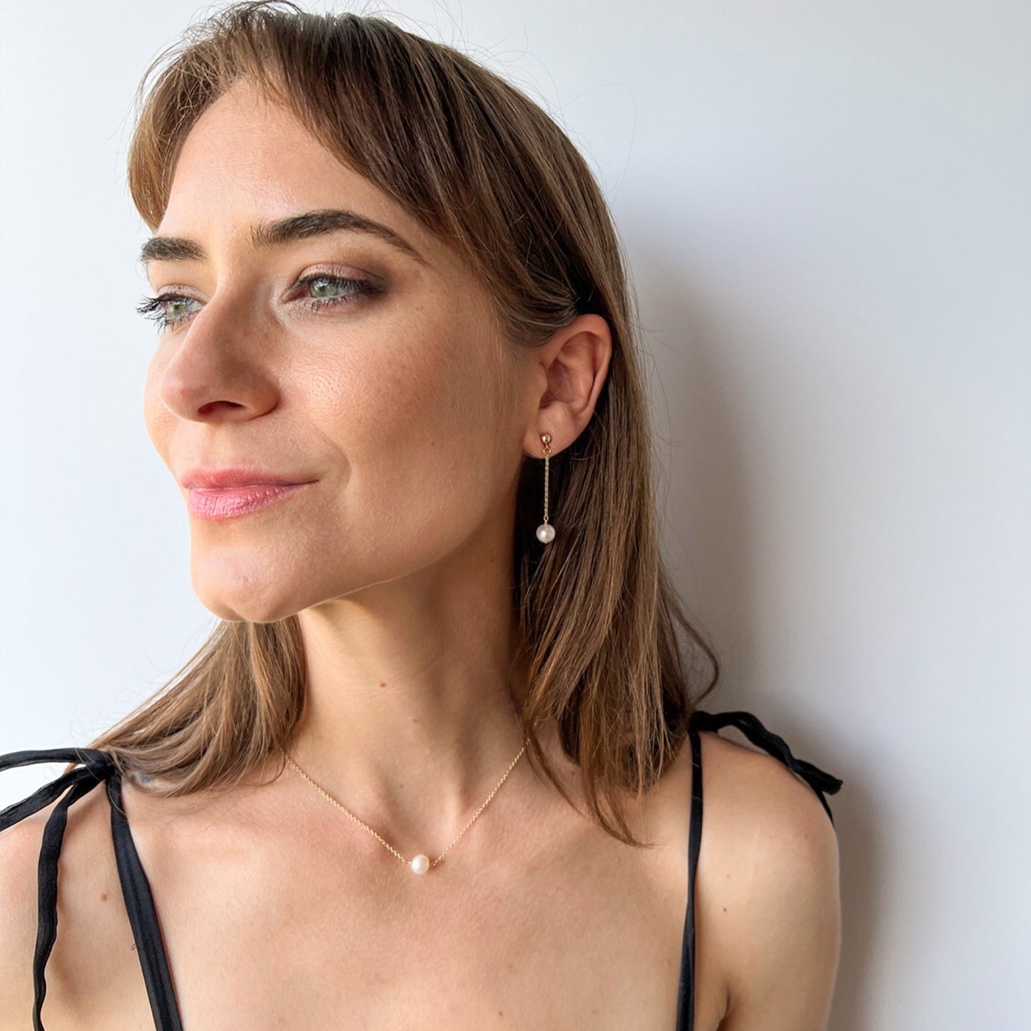 Model wearing the Lucia wedding pearl earrings and single pearl necklace