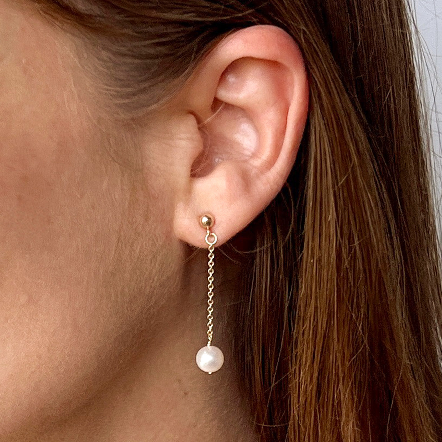 close up of model wearing Lucia pearl chain earrings with 4mm ball stud