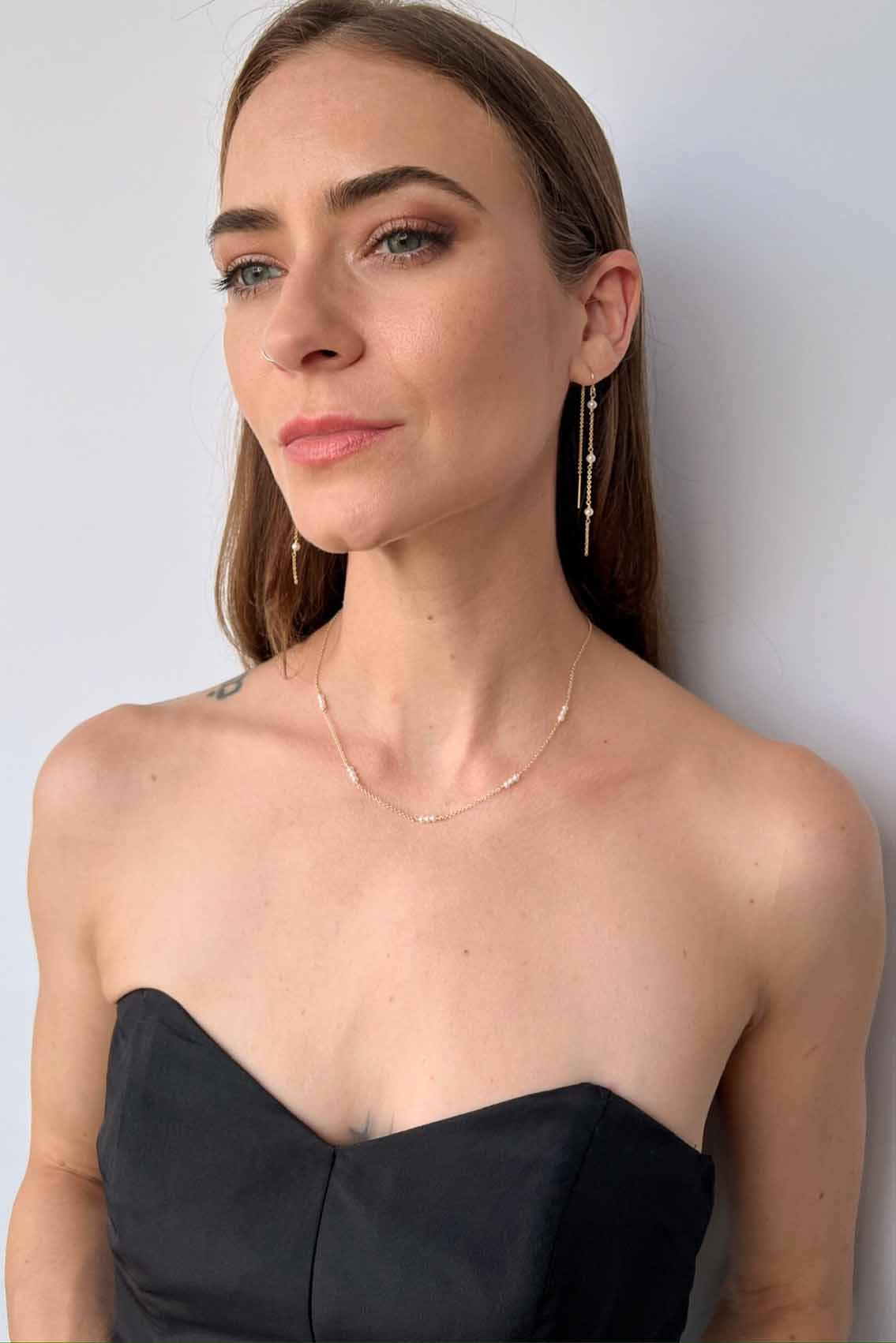 model wearing dainty pearl necklace and matching threader earrings