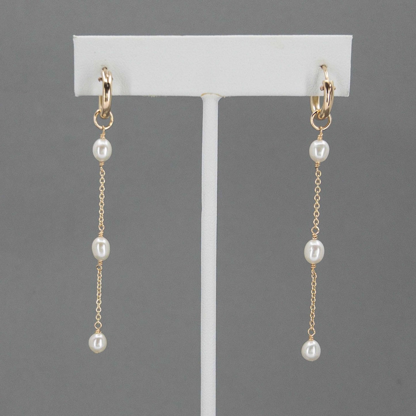 huggie hoop pearl earrings on earring stand