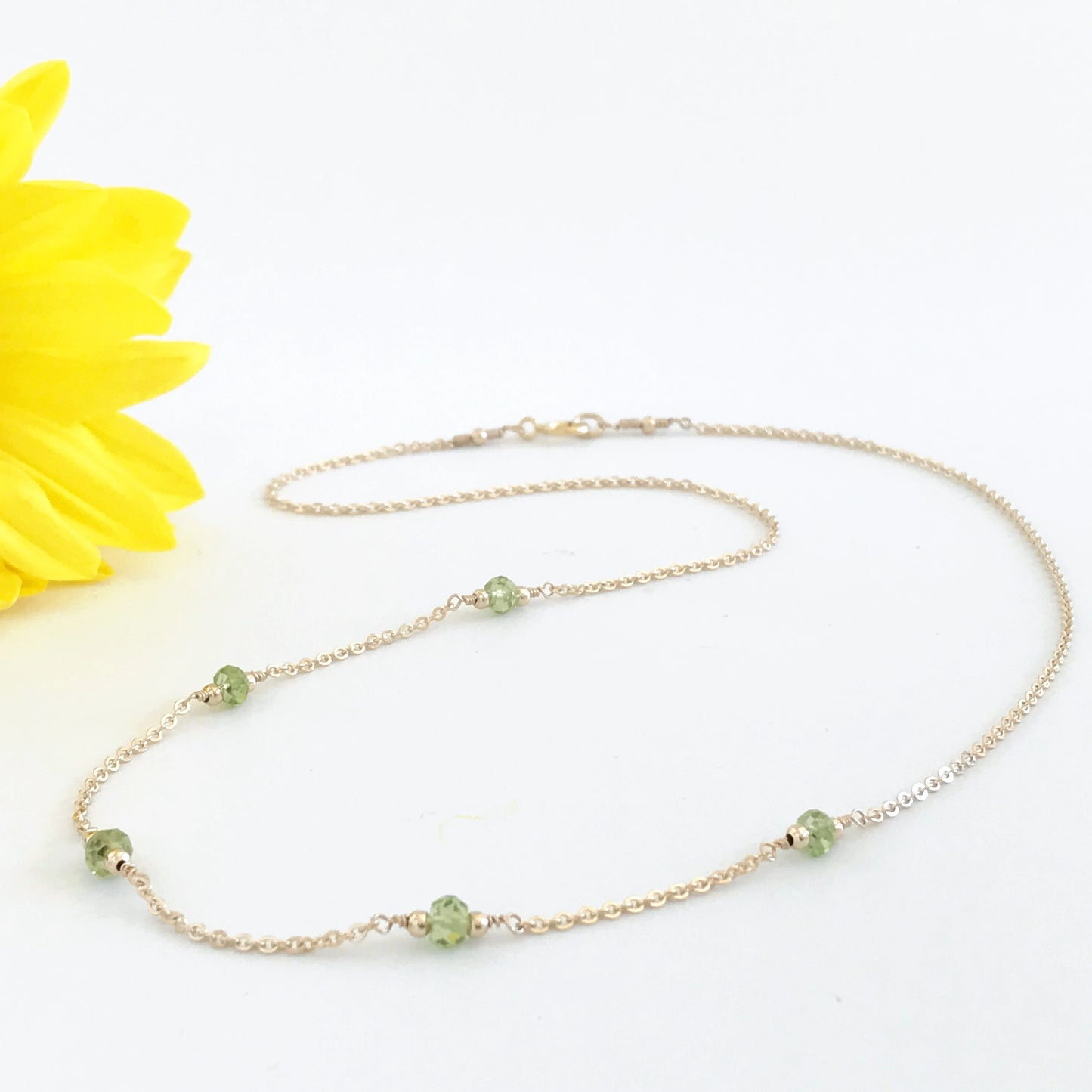 peridot station necklace shown in gold