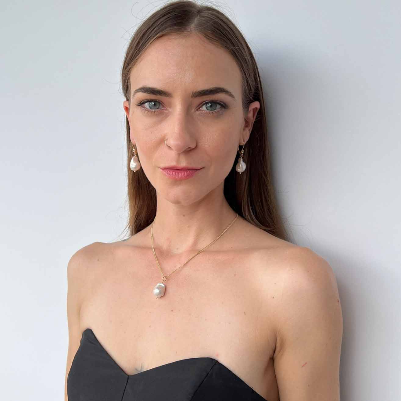 model wearing baroque pearl necklace and matching earrings from Raja collection