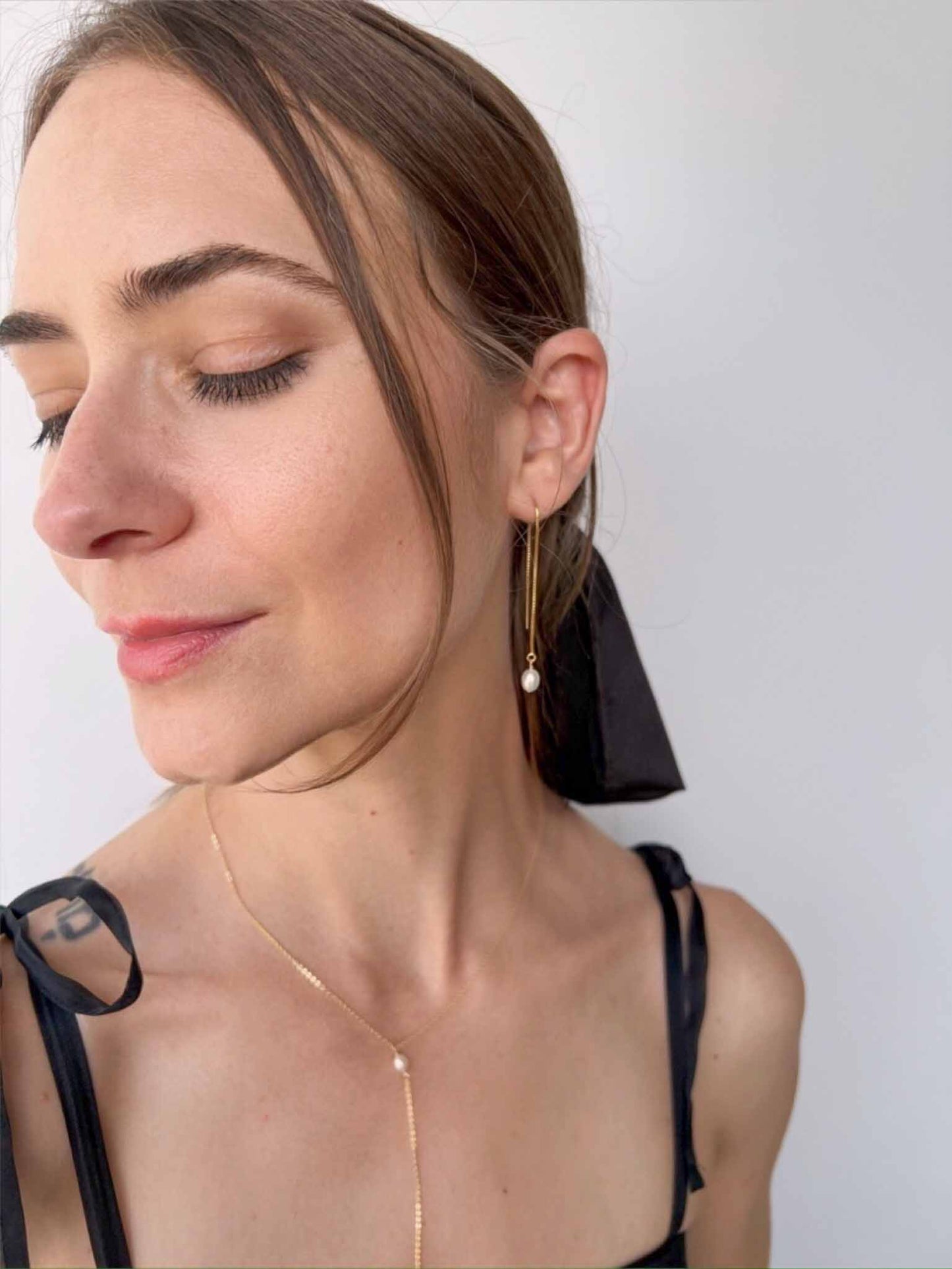model wearing lariat necklace and pearl chain earrings from Rosa Collection