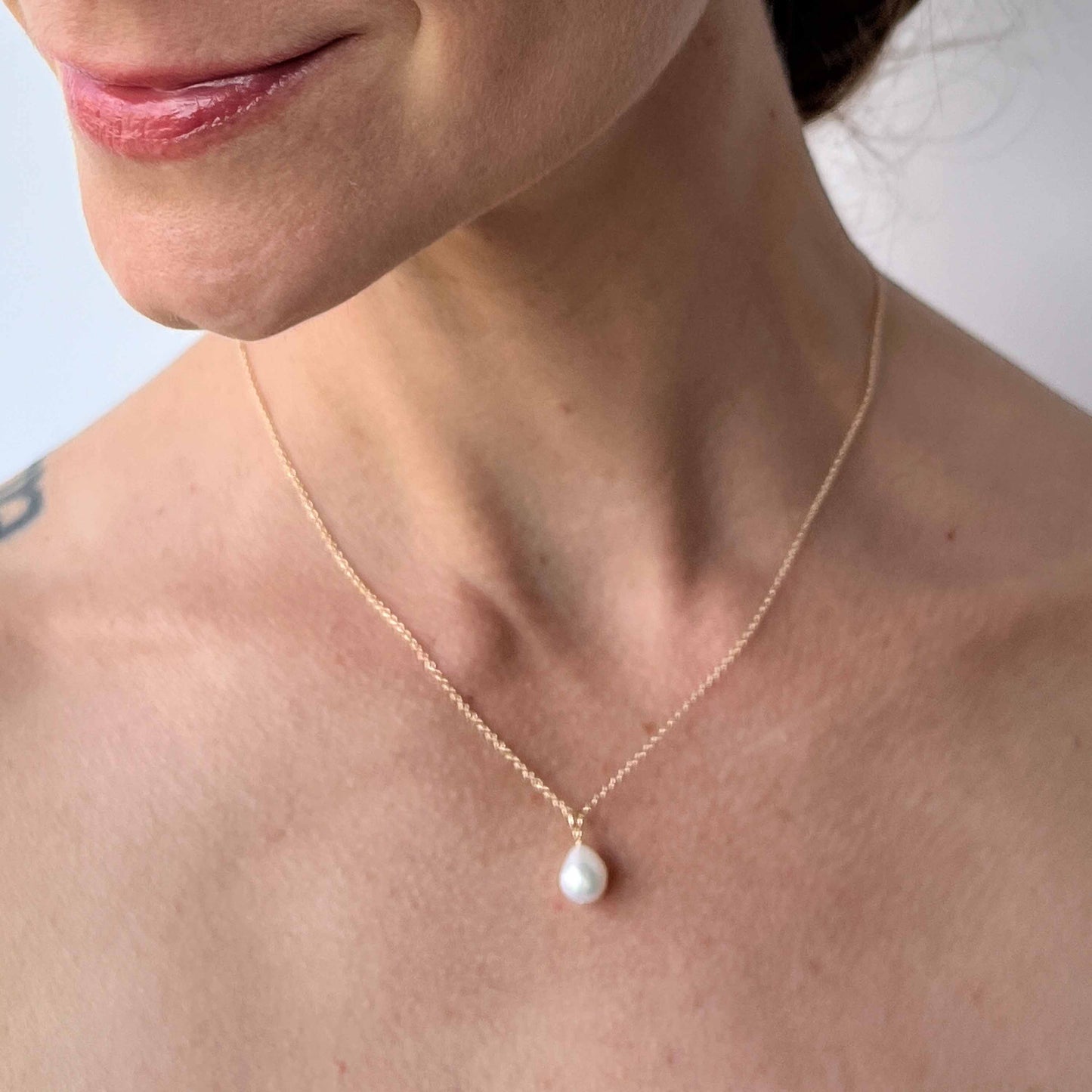 close up of model wearing single pearl necklace with baroque pearl from the Vivara Collection