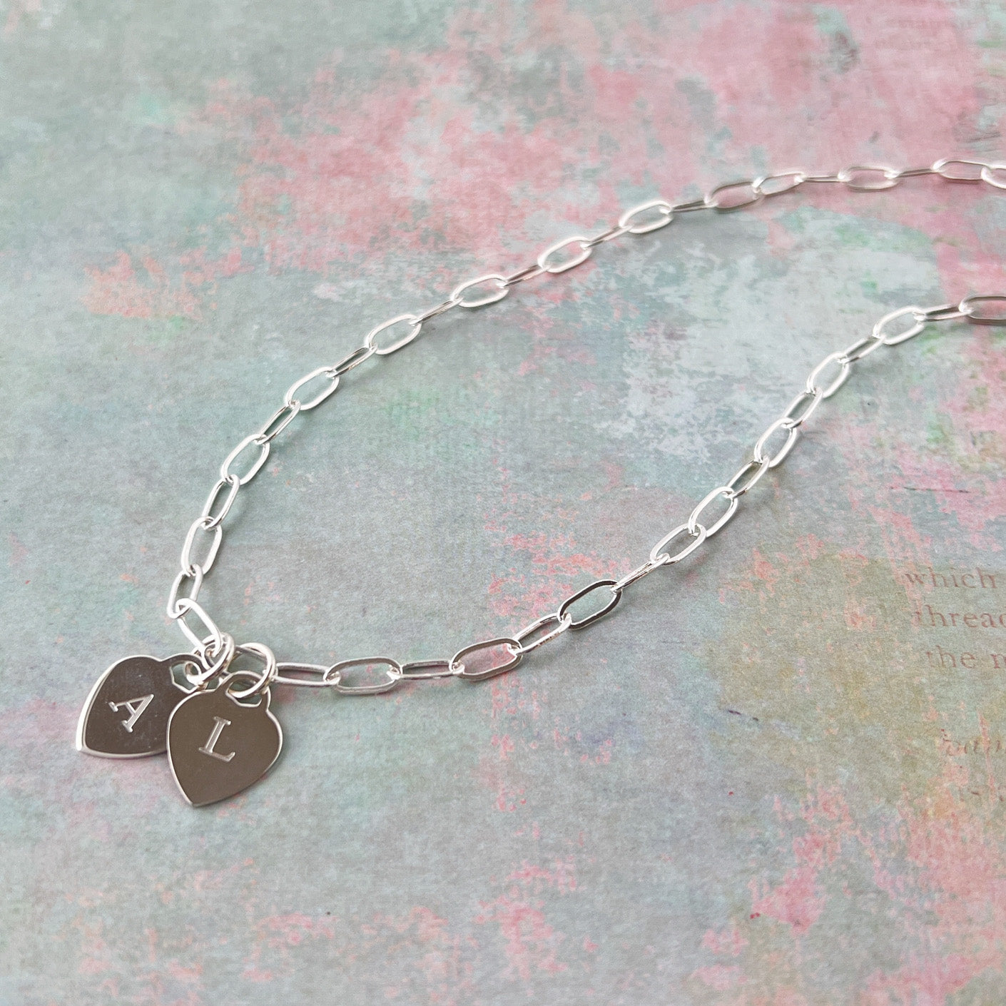 sterling silver paperclip chain with two heart charms with letters