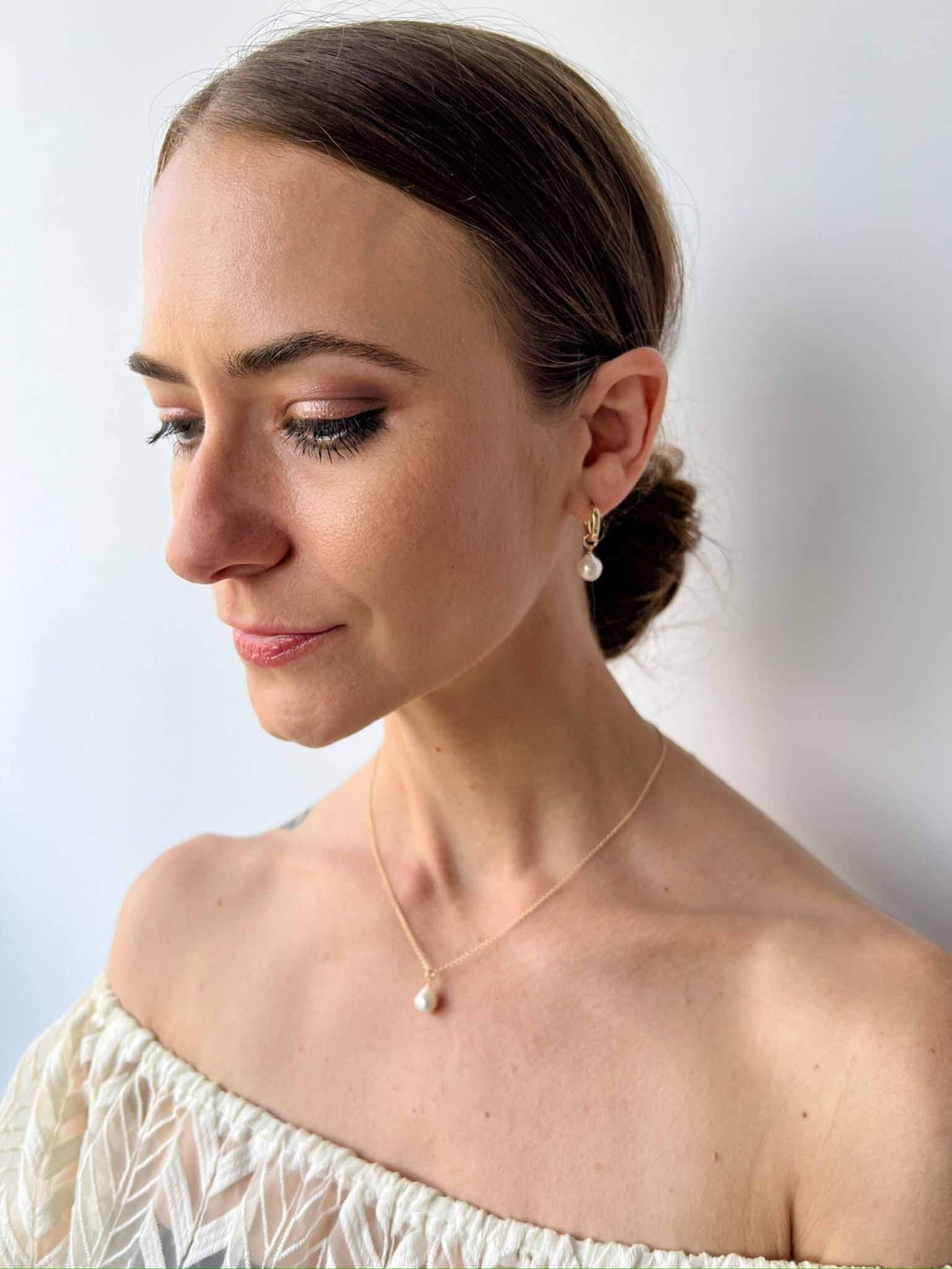 model wearing huggie hoop earrings and single pearl necklace from Vivara Collection