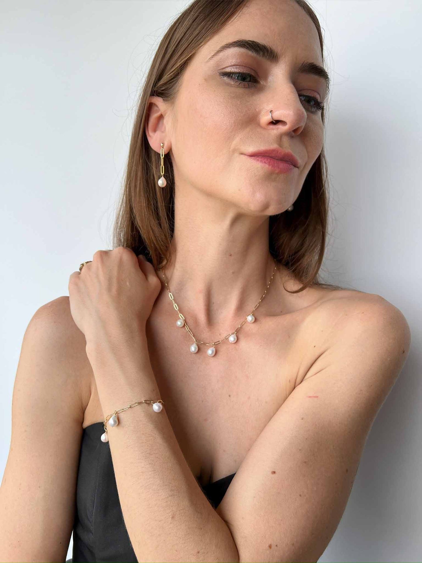 model wearing matching set of necklace, bracelet and earrings from the Vivara Collection of baroque pearls