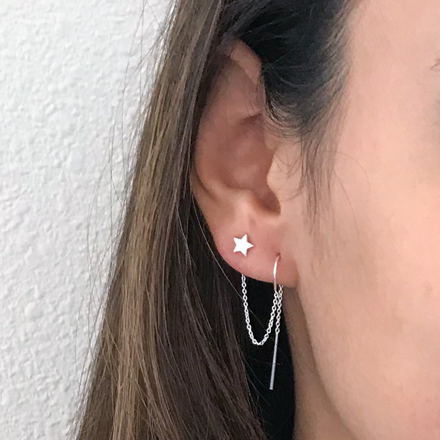 close up of model wearing sterling silver star earring for double piercing