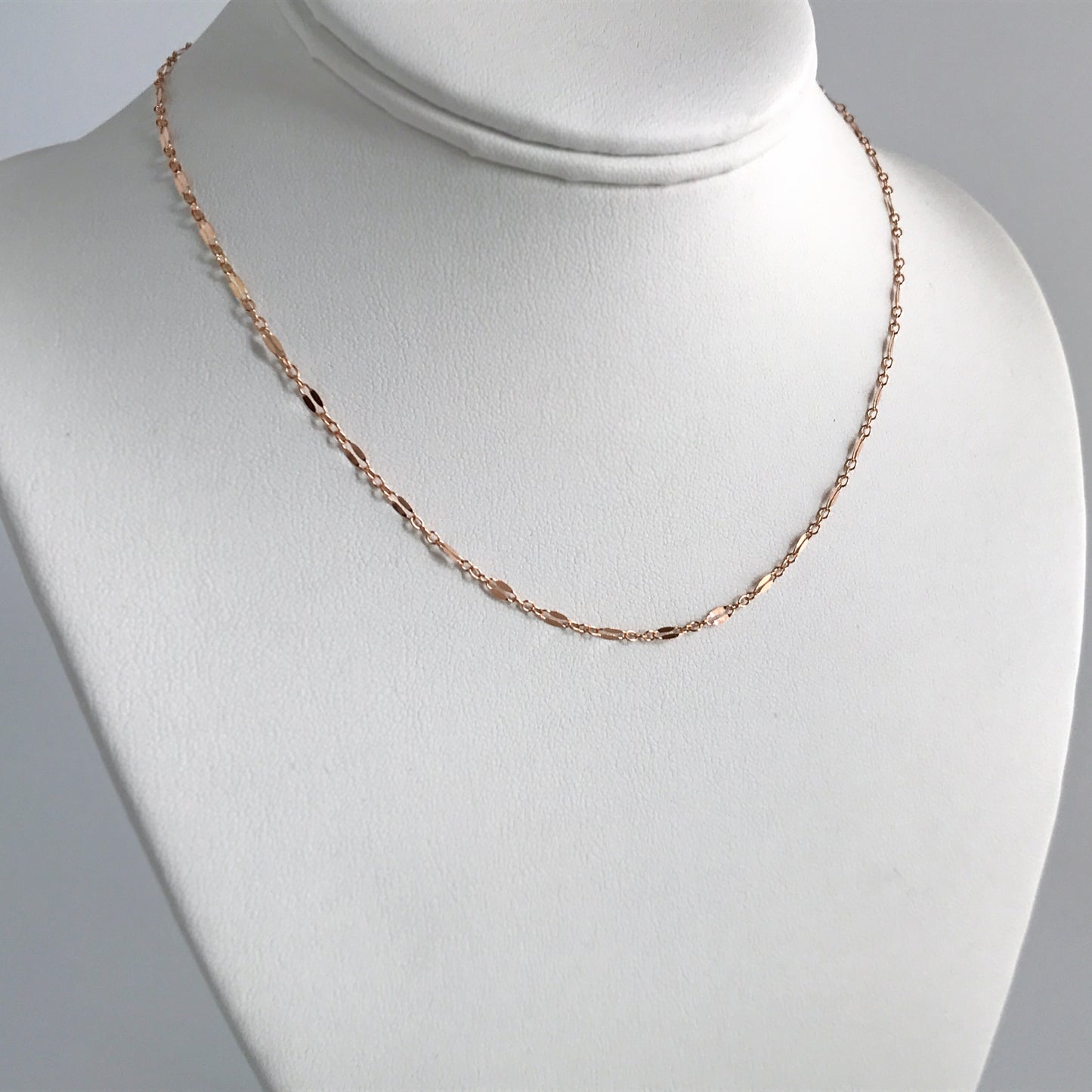 rose gold layering necklace on stand