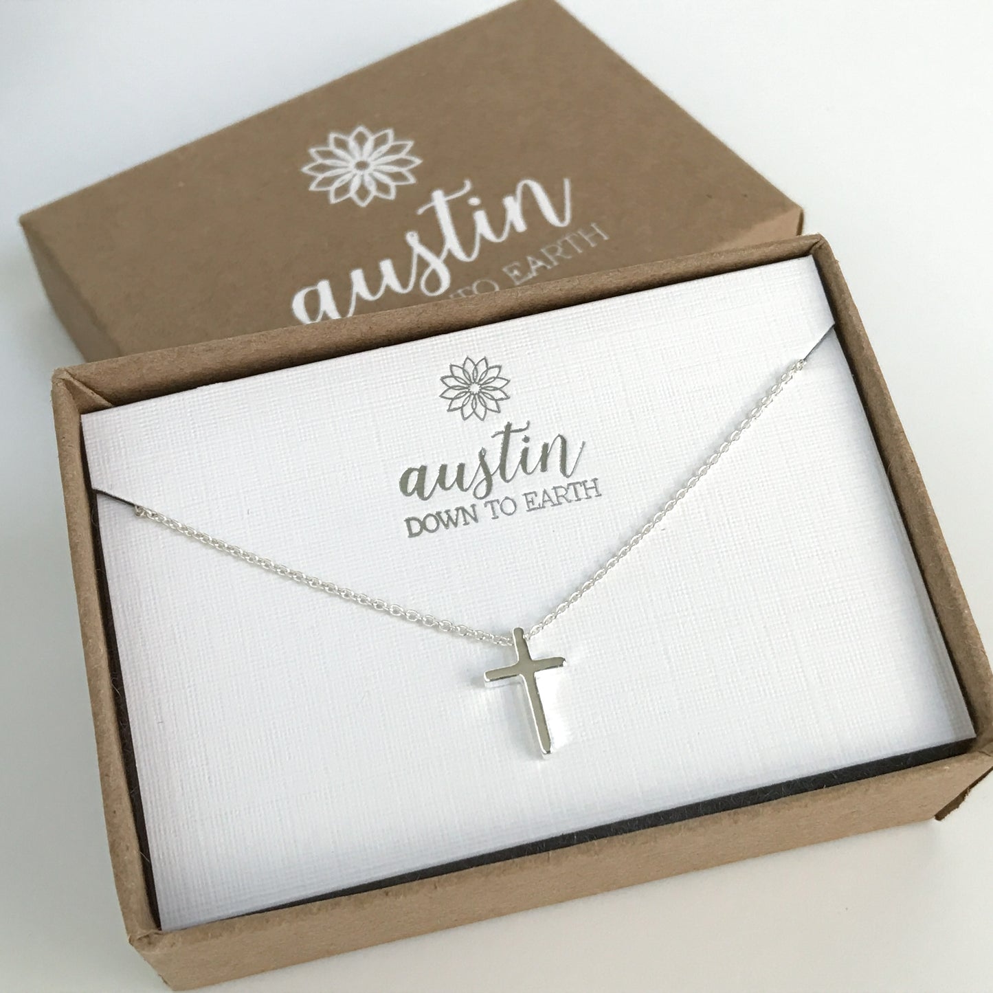 Tiny cross necklace shown in Austin Down to Earth gift box