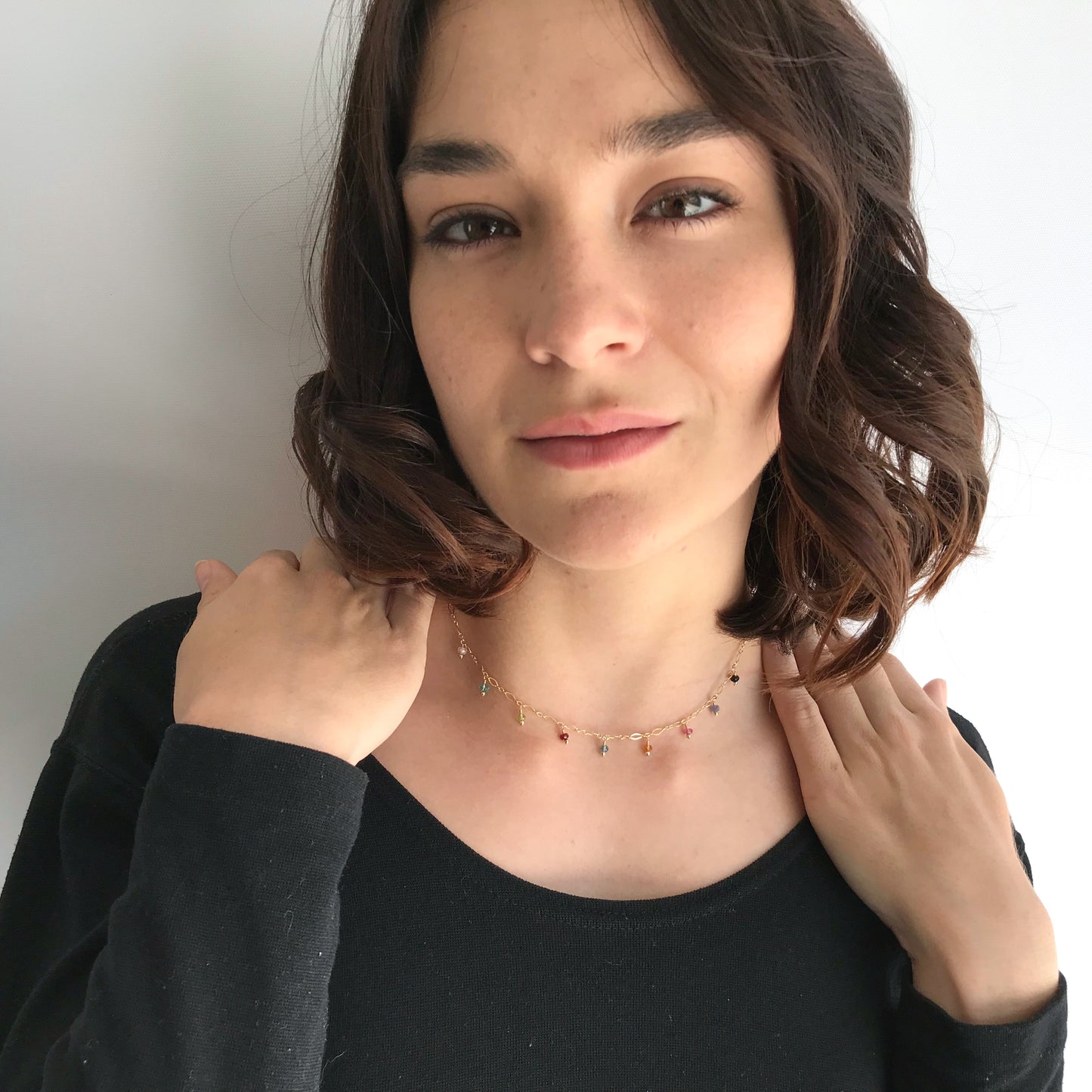model wearing gemstone necklace including ruby, moonstone, peridot, tourmaline, citrine and topaz