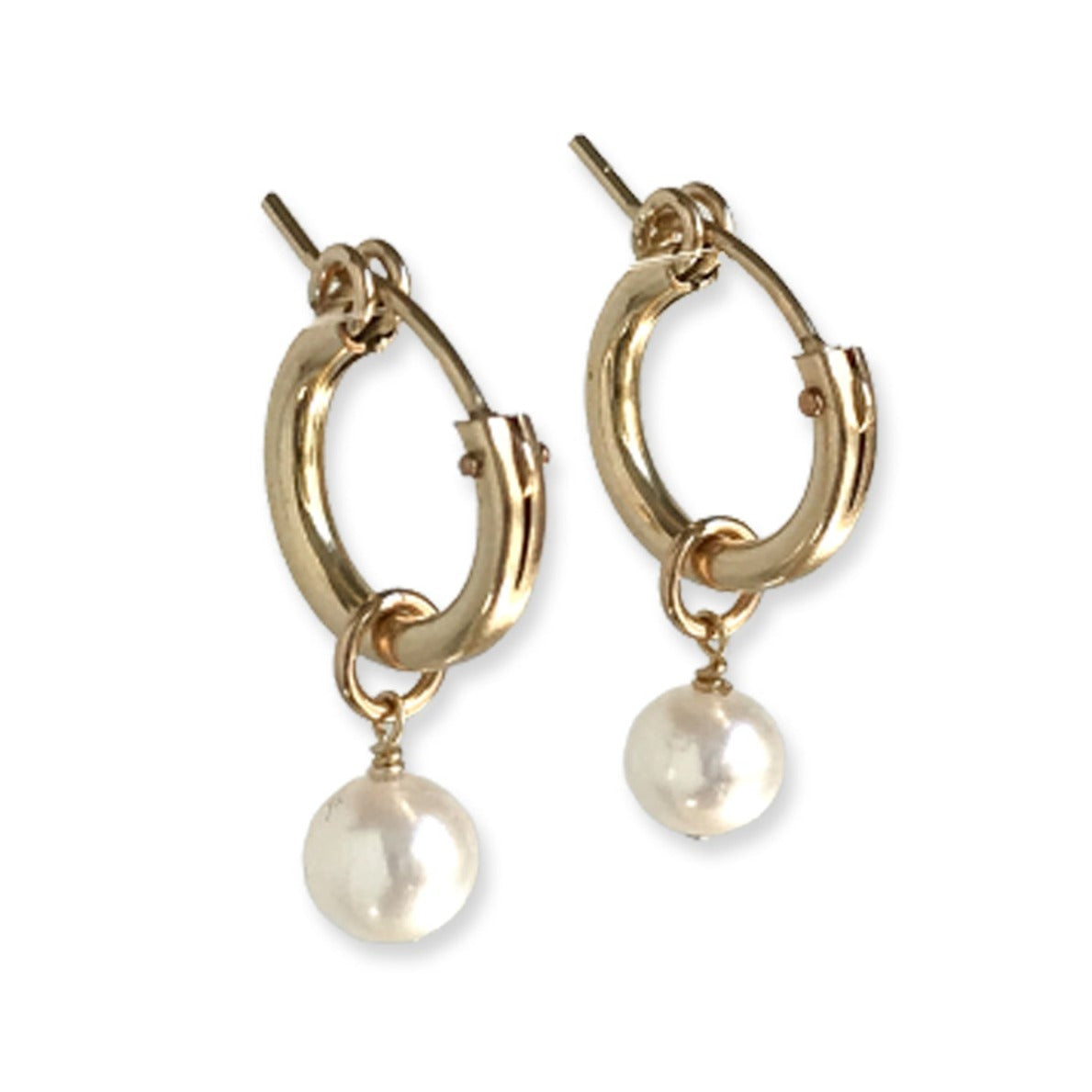 close up of pair of pearl huggie earrings in gold