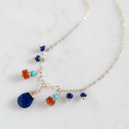 close up of lapis necklace with orange carnelian and small turquoise gems