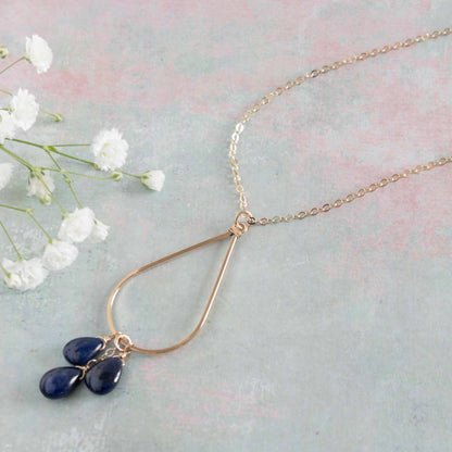 close up of sapphire necklace showing open teardrop and 3 sapphire gemstones in 14k gold filled