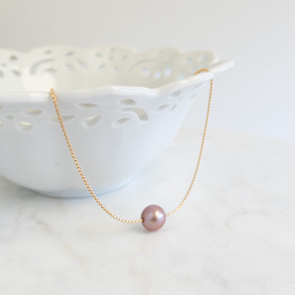 close up of Edison Pearl necklace, large pearl floating on a round box chain