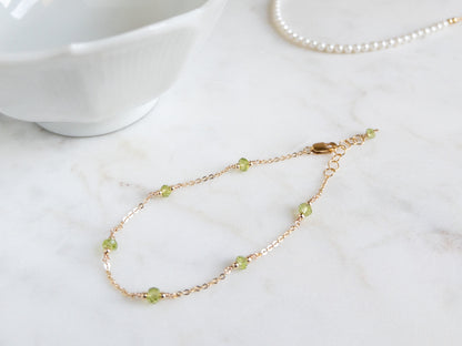14k gold filled peridot bracelet on marble background