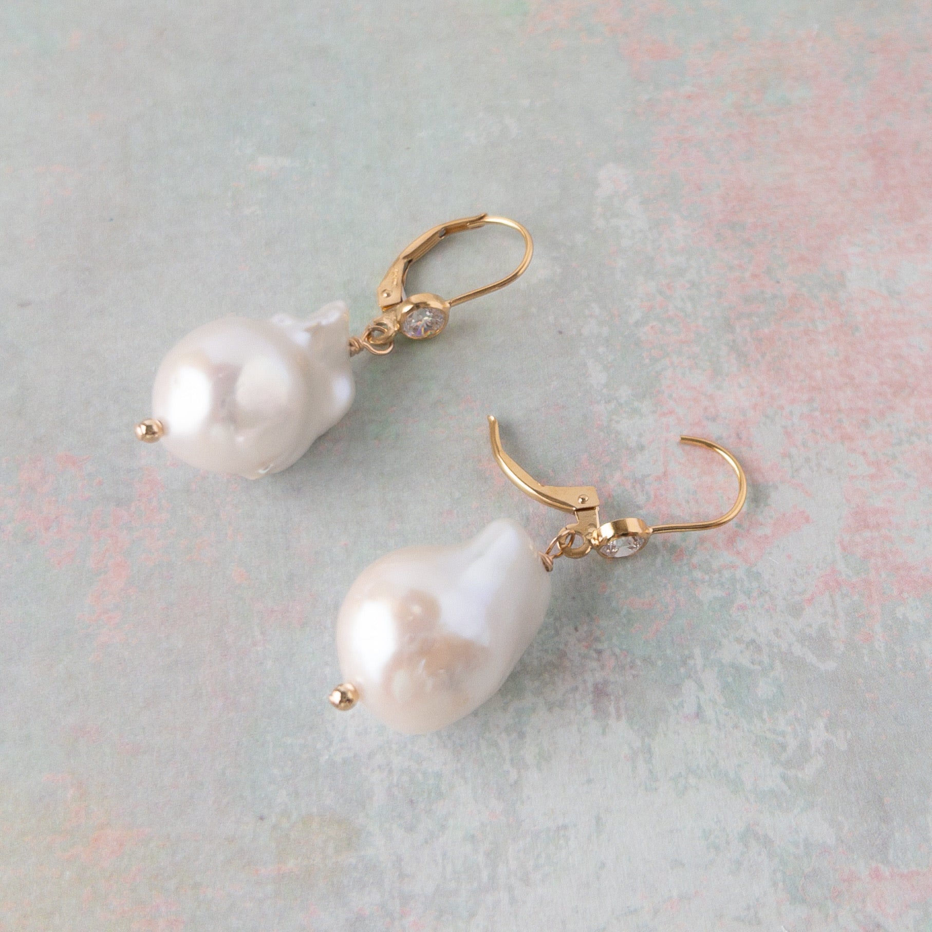 close up of large pearl earrings on leverback ear wires