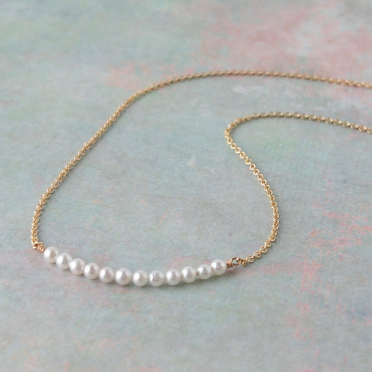 Dainty pearl necklace from the Gigi Collection featuring 12 tiny pearls