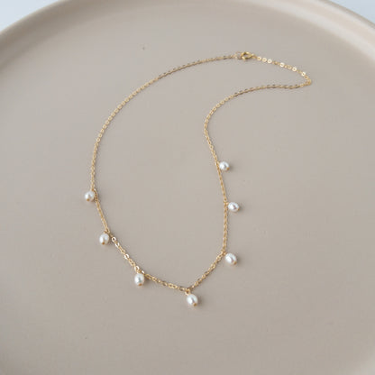 pearl drop necklace in 14k gold filled on peach colored surface