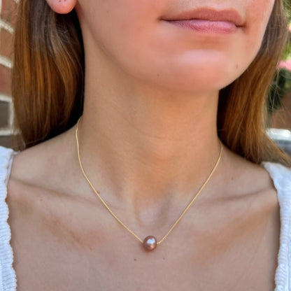 model wearing Edison floating pearl necklace.  Pearl is mauve pink color.