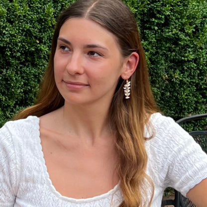 model wearing  long dangle pearl earrings