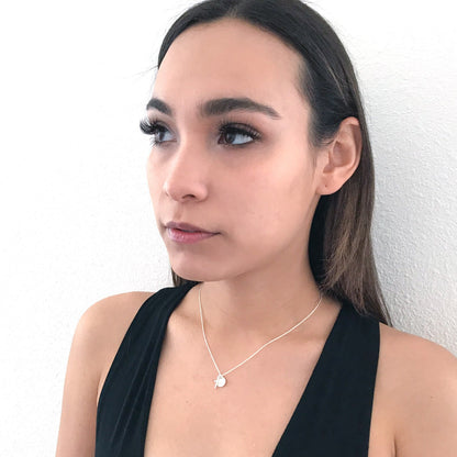 model wearing cross and initial charm necklace