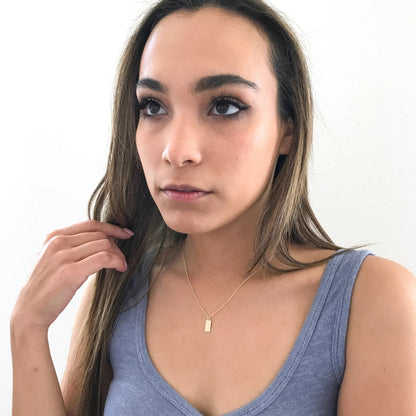model wearing dainty tag necklace
