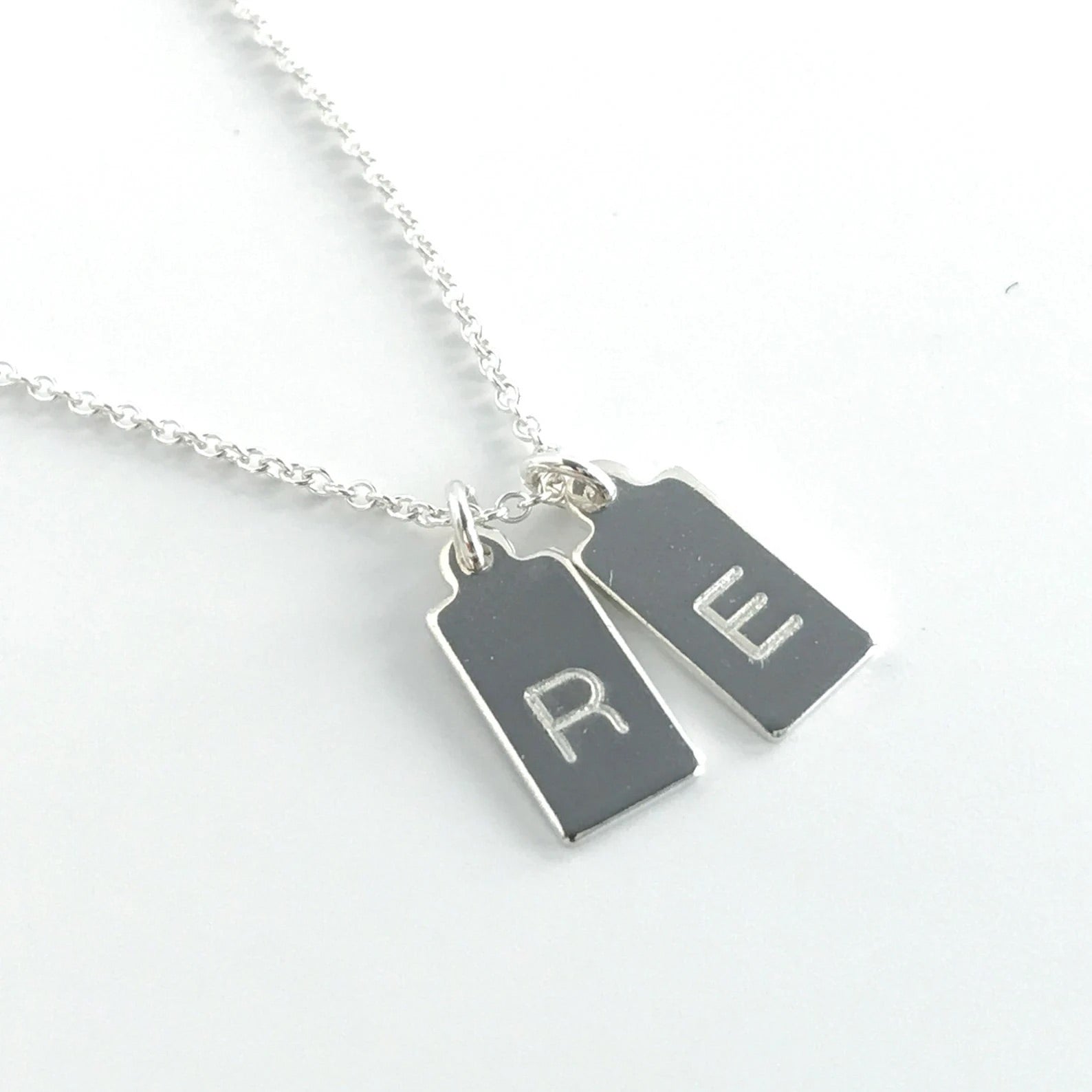 close up of single letter engraved mini dog tags