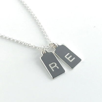 close up of single letter engraved mini dog tags