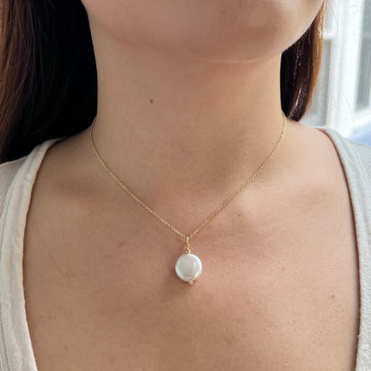 close up of model wearing coin pearl necklace, a white freshwater pearl shaped like a coin