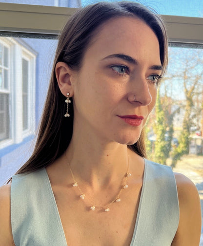 model wearing pearl dangle earrings and matching pearl cluster necklace