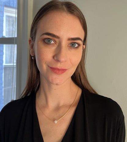 model wearing single white pearl on gold filled chain