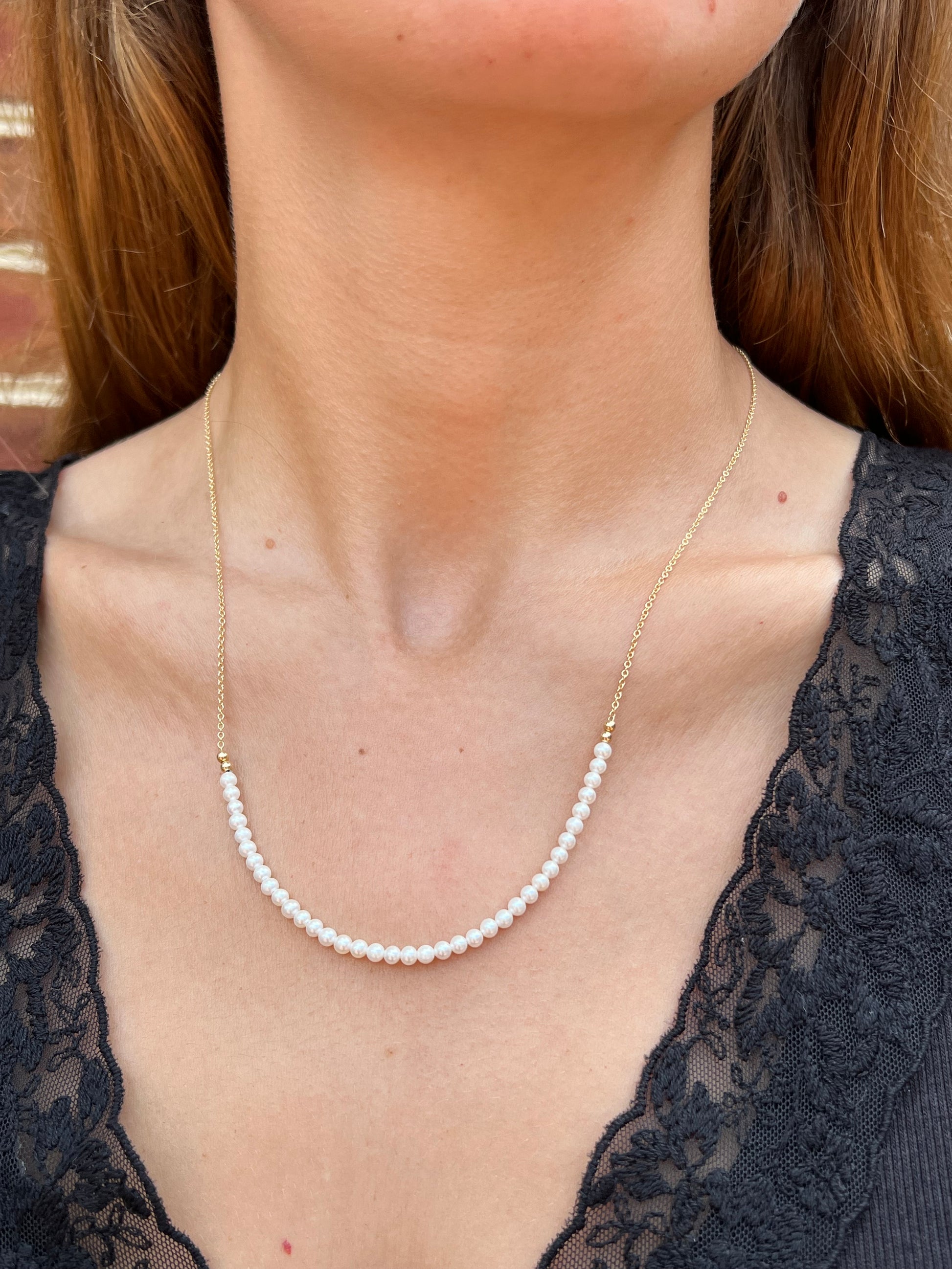 model wearing row of pearls on gold chain