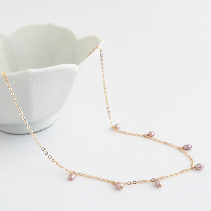 close up of pink pearl necklace laying on table