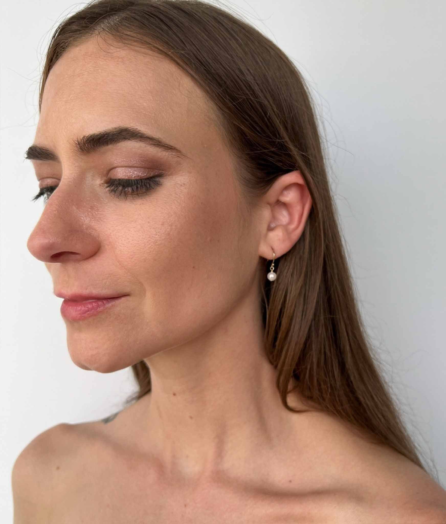 model wearing small pearl drop earrings  made with freshwater pearls