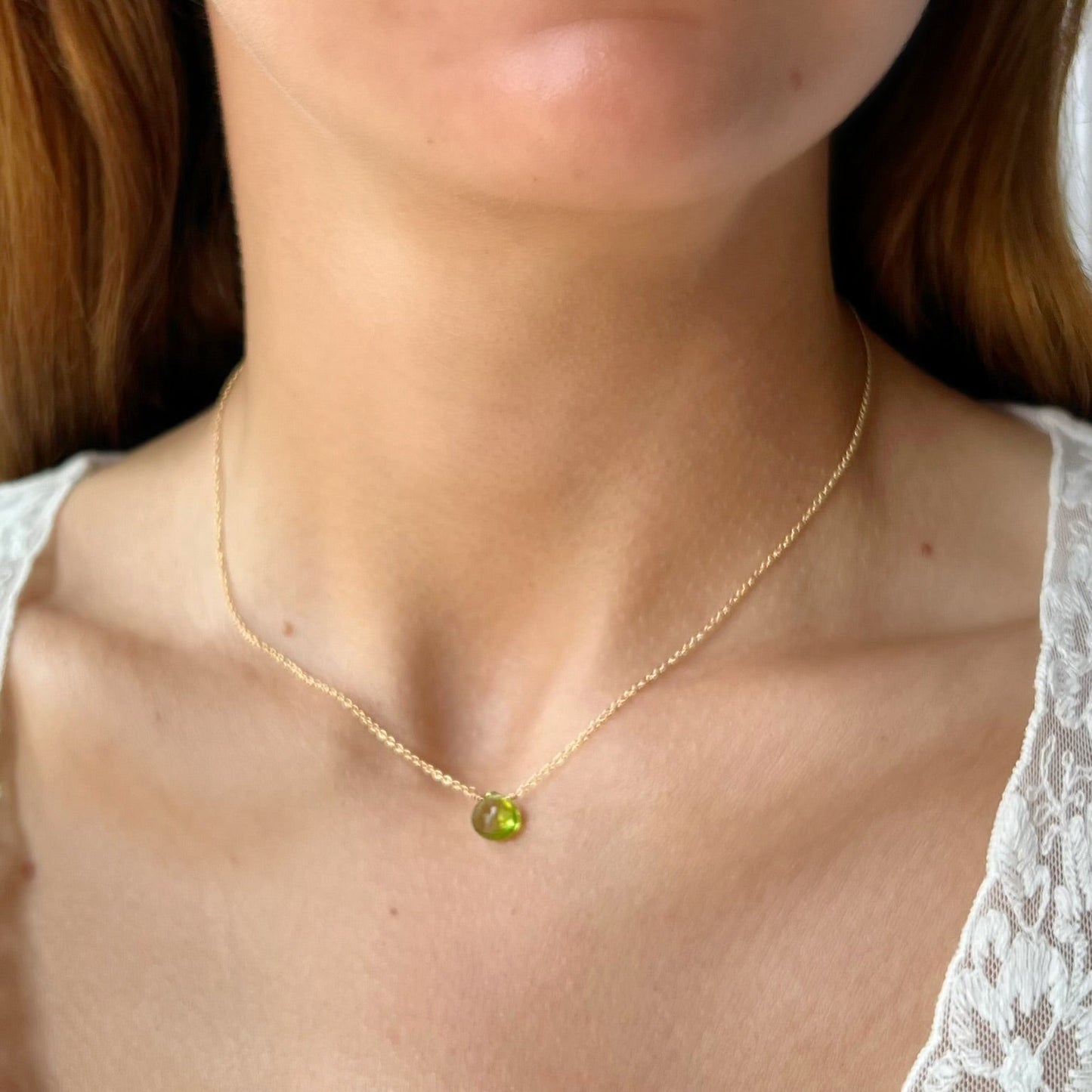 close up of peridot briolette on cable chain on model