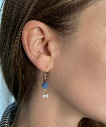 Close up of model wearing kyanite pearl and ruby dangle earrings