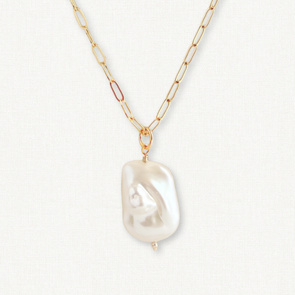 close up of large baroque pearl pendant on paperclip chain