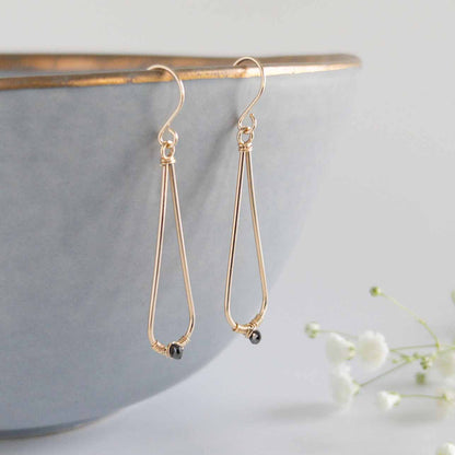 close up of 14k gold filled black diamond teardrop dangle earrings