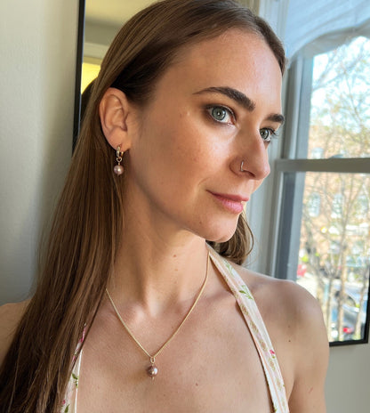 model wearing pink pearl necklace with matching earrings