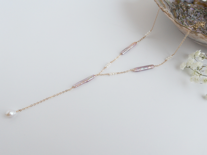 pearl lariat necklace on white background with lavender pink stick pearls and tiny white pearls