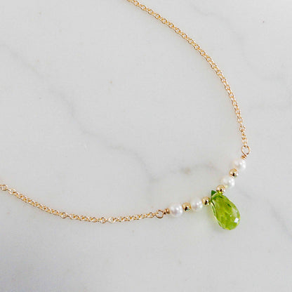 close up of peridot necklace with tiny pearls on gold chain. Also available in sterling silver