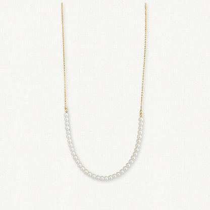 row of small pearls draped in the front of a gold chain