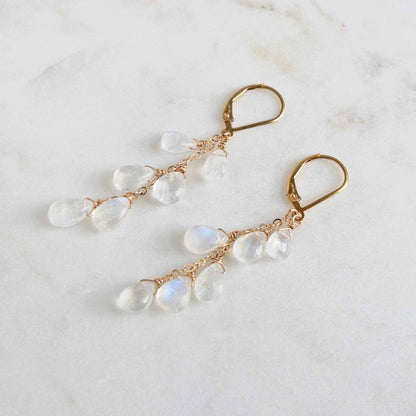 close up photo of gold leverback earrings with dangling moonstones